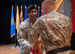 Maj. Gen. Michel M. Russell Sr., outgoing commanding general, 1st Theater Sustainment Command (Left), passes the 1st TSC unit colors to the reviewing officer, Lt. Gen. Patrick Frank, commanding general, U.S. Army Central (Right), during a change of command ceremony on Fort Knox, Kentucky, June 23, 2023. Russell relinquished command after two years leading the First Team and more than 39 total years of U.S. Army service.