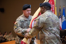 Brig. Gen Eric P. Shirley, incoming commanding general, 1st Theater Sustainment Command (Left), returns the 1st TSC unit colors to Command Sgt. Maj. Albert E. Richardson Jr., senior enlisted advisor, 1st TSC (Right), during a change of command ceremony on Fort Knox, Kentucky, June 23, 2023. The act of returning the colors to the keeper of the colors for safekeeping signifies the seamless completion of the change of command.