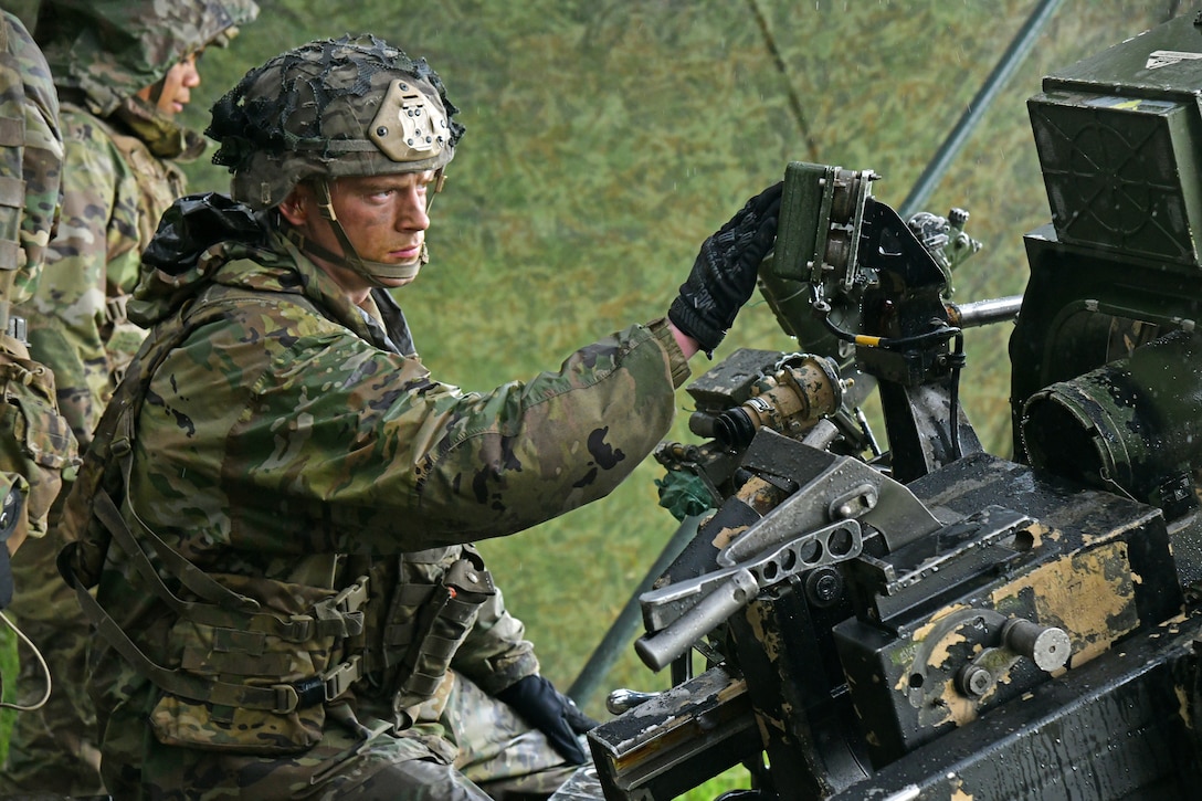 A solider sets up a howitzer.