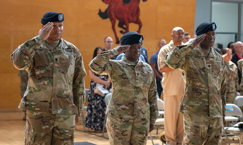 (Left to right) Outgoing Army Field Support Battalion-Mannheim Commander Lt. Col. Brian Astwood, 405th Army Field Support Brigade Commander Col. Crystal Hills and incoming AFSBn-Mannheim Commander Lt. Col. Omar McKen render honors to the National Colors at the AFSBn-Mannheim change of command ceremony June 26 at Coleman worksite in Mannheim, Germany. (photo by Elisabeth Paqué, Training Support Center Kaiserslautern)