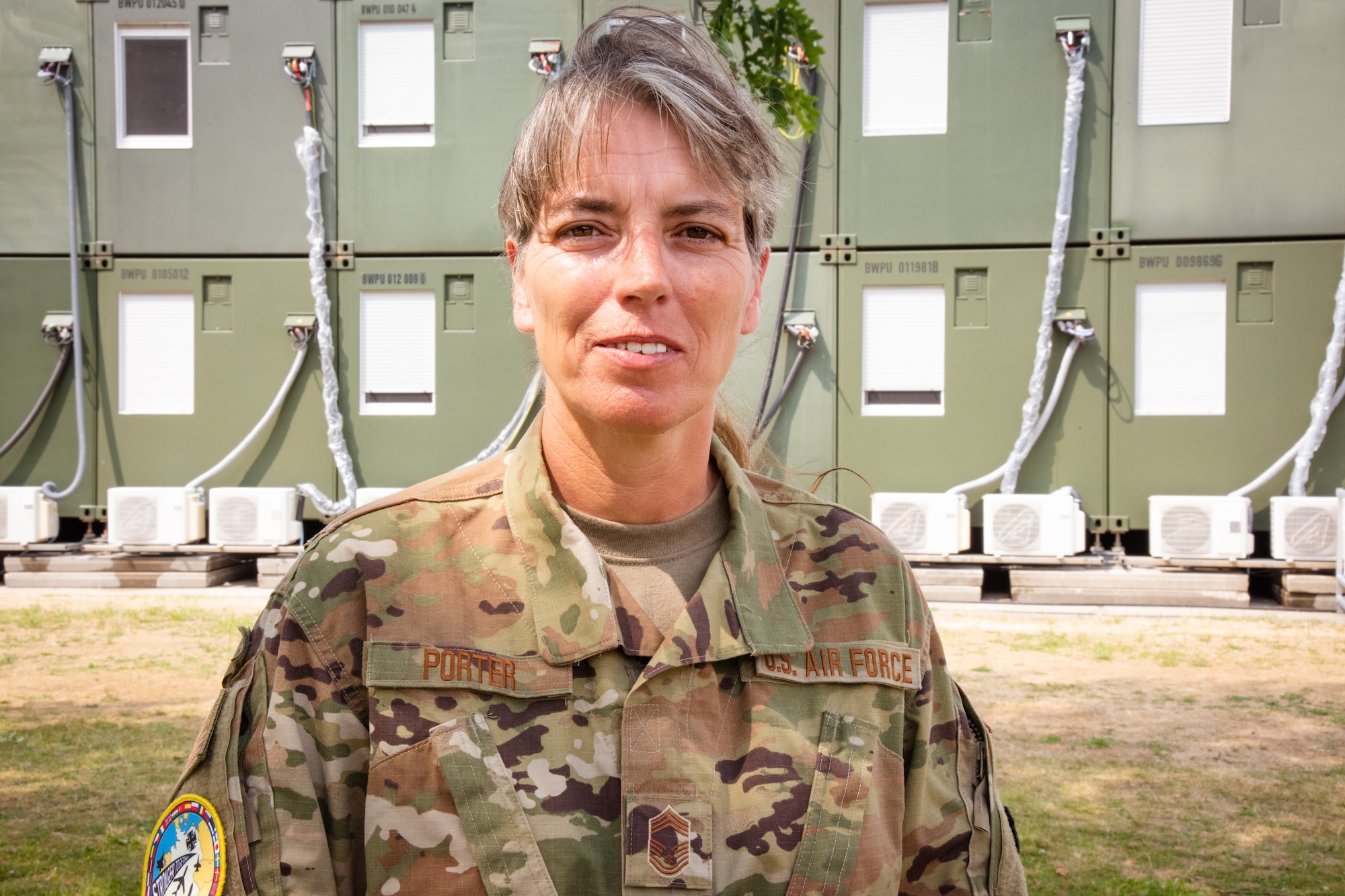 U.S. Air Force Chief Master Sgt. Dawn Porter, chief, 127th Force Support Squadron, 127th Wing, Michigan National Guard, poses for a photo outside non-commissioned officer living quarters at Kropp, Germany, June 19, 2023. A grandmother with nearly three decades of time in service, Porter has dedicated the vast majority of her enlistment to serving Airmen because she is passionate about the career field. (U.S. Air National Guard photo by Tech. Sgt. Chelsea E. FitzPatrick)