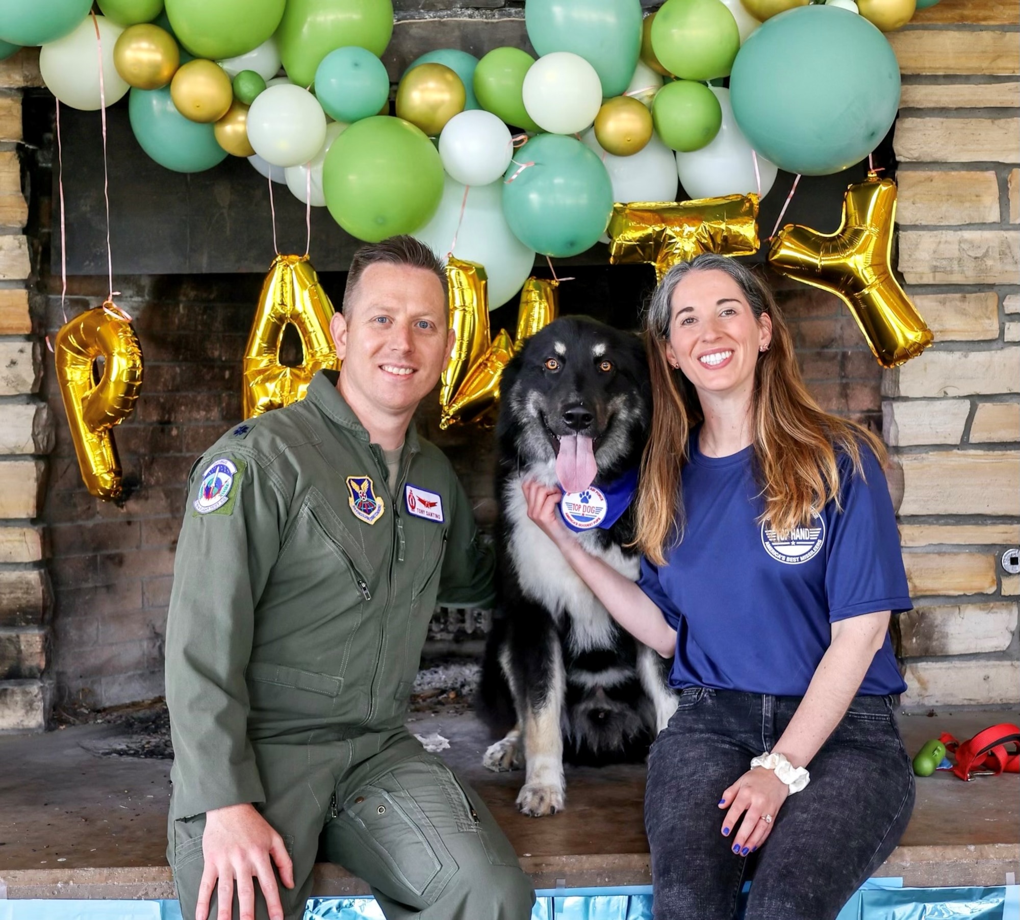 Man and women take a photo with a dog.