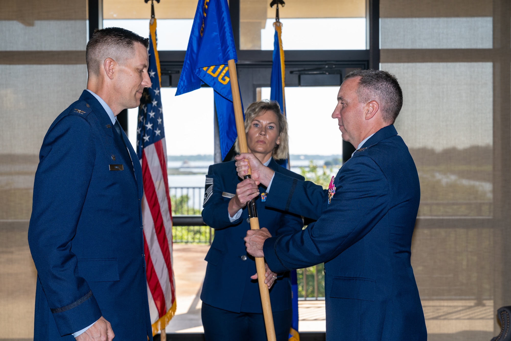 U.S. Air Force Chief Master Sgt. Jacey McDuffie, 81st MDG senior enlisted leader, passes the guidon to Col. Christopher Estridge, 81st Medical Group outgoing commander, during the 81st MDG change of command ceremony at Keesler Air Force Base, Mississippi, June 23, 2023.