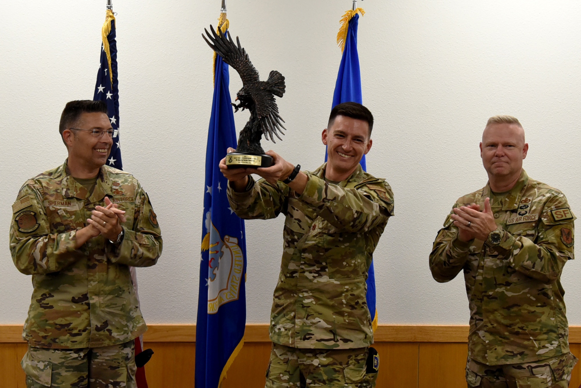 U.S. Air Force Brig. Gen. Thomas Sherman, Security Forces director, along with Master Sgt. Donald Gallagher, Security Forces career field manager, presents Maj. Christopher Gresham, 7th Security Forces Squadron commander, with an award at Dyess Air Force Base, Texas, June 15, 2023. Sherman visited Dyess to present the 7th SFS with the Air Force Best Medium Sized Security Forces Squadron Award along with seeing new innovations including the robotic dog, a new GPS system, upgraded flack vests and more. (U.S. Air Force photo by Senior Airman Sophia Robello)