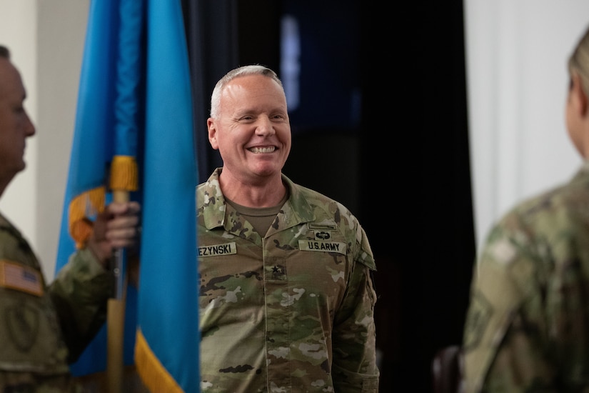 Brig. Gen. Joseph Dziezynski, outgoing MIRC commanding general, smiles as he prepares to accept the unit colors.
