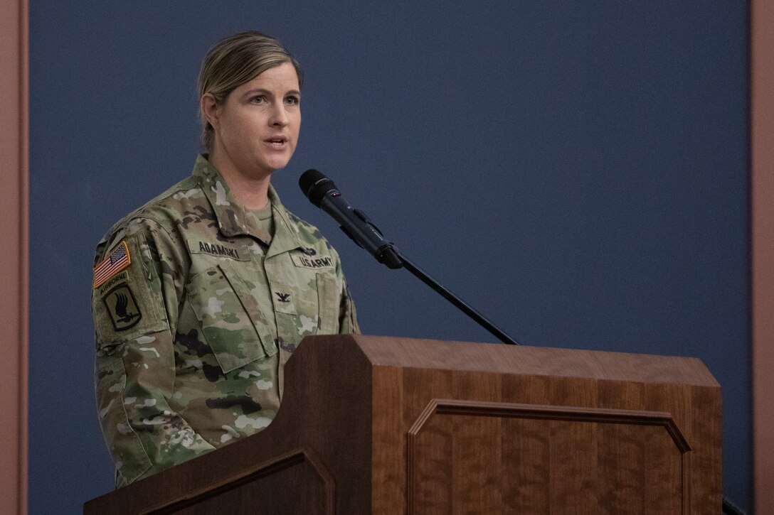 Col. Melissa Adamski, MIRC commander, addresses Soldiers and guests from behind a podium.