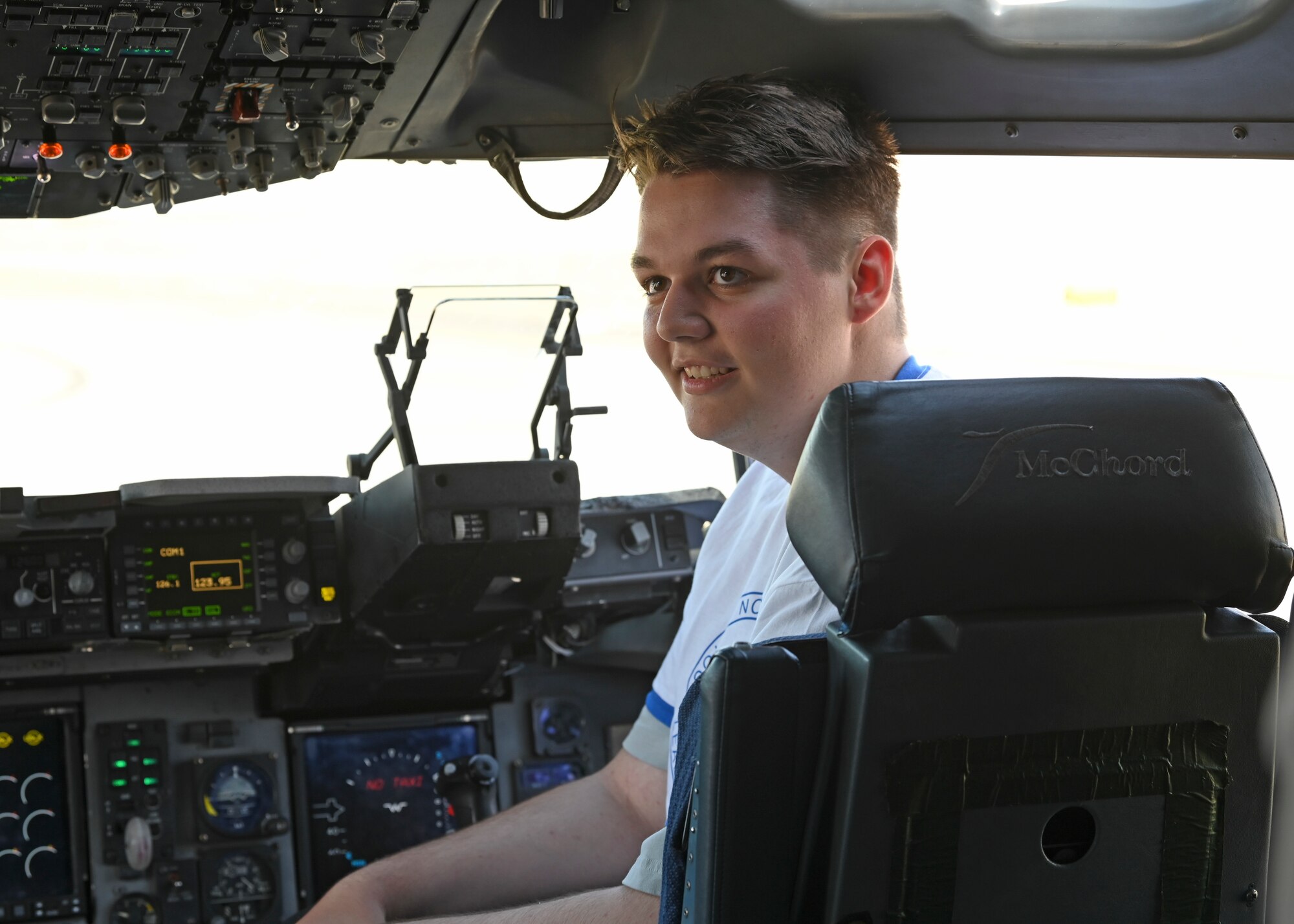 A student with the North West Youth Leadership Conference sits in the cockpit of a C-17 Globemaster III at Joint Base Lewis-McChord, Washington, June 26, 2023. The NWYLC participants visited McChord Field where they received a mission brief from Col. Sergio Anaya, 62d Airlift Wing commander, toured a C-17, and visited the JBLM Fire & Emergency Services Station 105. (U.S. Air Force photo by Senior Airman Callie Norton)