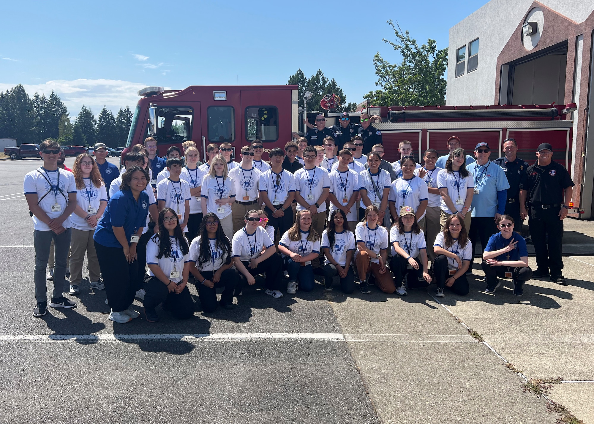 Students with the North West Youth Leadership Conference pose for a group photo with Station 105 firefighters at Joint Base Lewis-McChord, Washington, June 26, 2023. The NWYLC participants visited McChord Field where they received a mission brief from Col. Sergio Anaya, 62d Airlift Wing commander, toured a C-17, and Station 105. (U.S. Air Force photo by Senior Airman Callie Norton)