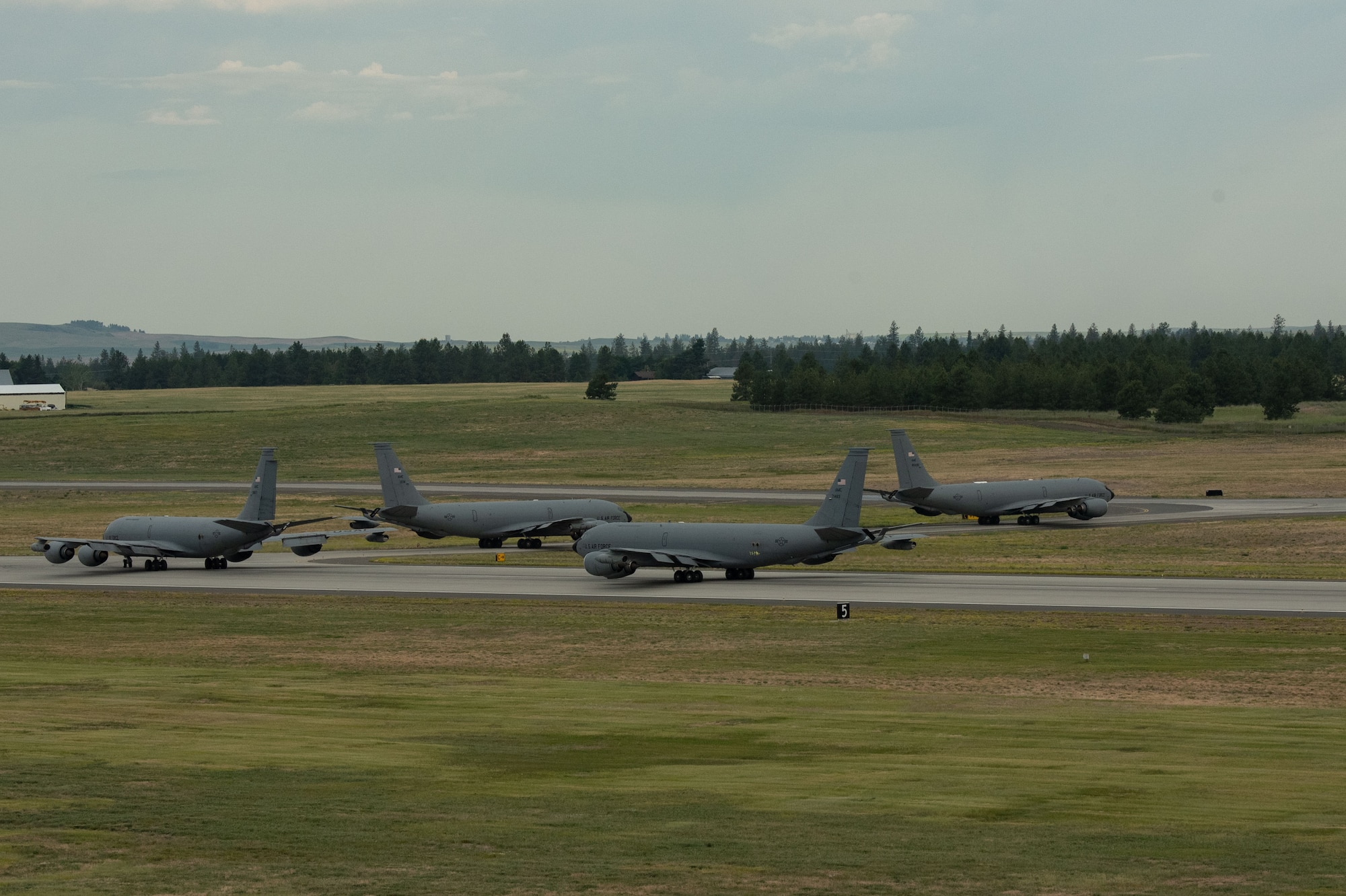 Four KC-135 Stratotankers taxi into position before minimum-interval takeoffs as part of Operation Centennial Contact at Fairchild Air Force Base, Washington, June 27, 2023. The movement, which included stops at Yellowstone National Park, Mount Rushmore and Glacier National Park, was part of Air Mobility Command’s celebration of 100 years air refueling operations and demonstrated the 92nd Air Refueling Wing’s global reach capabilities. Since its inception in 1923, Air refueling has become a crucial component of military and civilian aviation operations around the world by extending the range and endurance of aircraft and enabling them to complete missions that would otherwise be impossible or require multiple stops. As a result, this capability is essential for strategic and tactical operations, as well as humanitarian relief efforts in support of AMC, U.S. Transportation Command and Department of Defense priorities. (U.S. Air Force photo by Airman 1st Class Clare Werner)