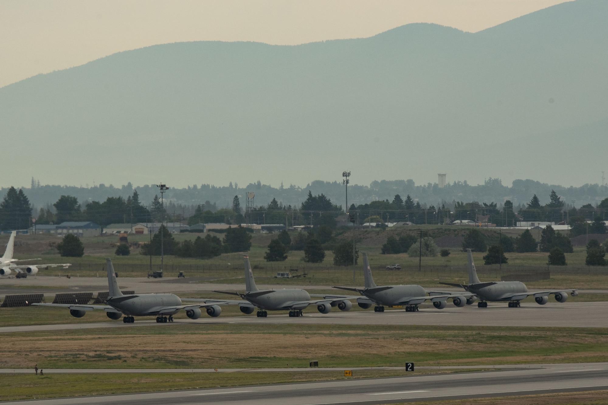 Four KC-135 Stratotankers taxi into position before minimum-interval takeoffs as part of Operation Centennial Contact at Fairchild Air Force Base, Washington, June 27, 2023. The movement, which included stops at Yellowstone National Park, Mount Rushmore and Glacier National Park, was part of Air Mobility Command’s celebration of 100 years air refueling operations and demonstrated the 92nd Air Refueling Wing’s global reach capabilities. Since its inception in 1923, Air refueling has become a crucial component of military and civilian aviation operations around the world by extending the range and endurance of aircraft and enabling them to complete missions that would otherwise be impossible or require multiple stops. As a result, this capability is essential for strategic and tactical operations, as well as humanitarian relief efforts in support of AMC, U.S. Transportation Command and Department of Defense priorities. (U.S. Air Force photo by Airman 1st Class Clare Werner)
