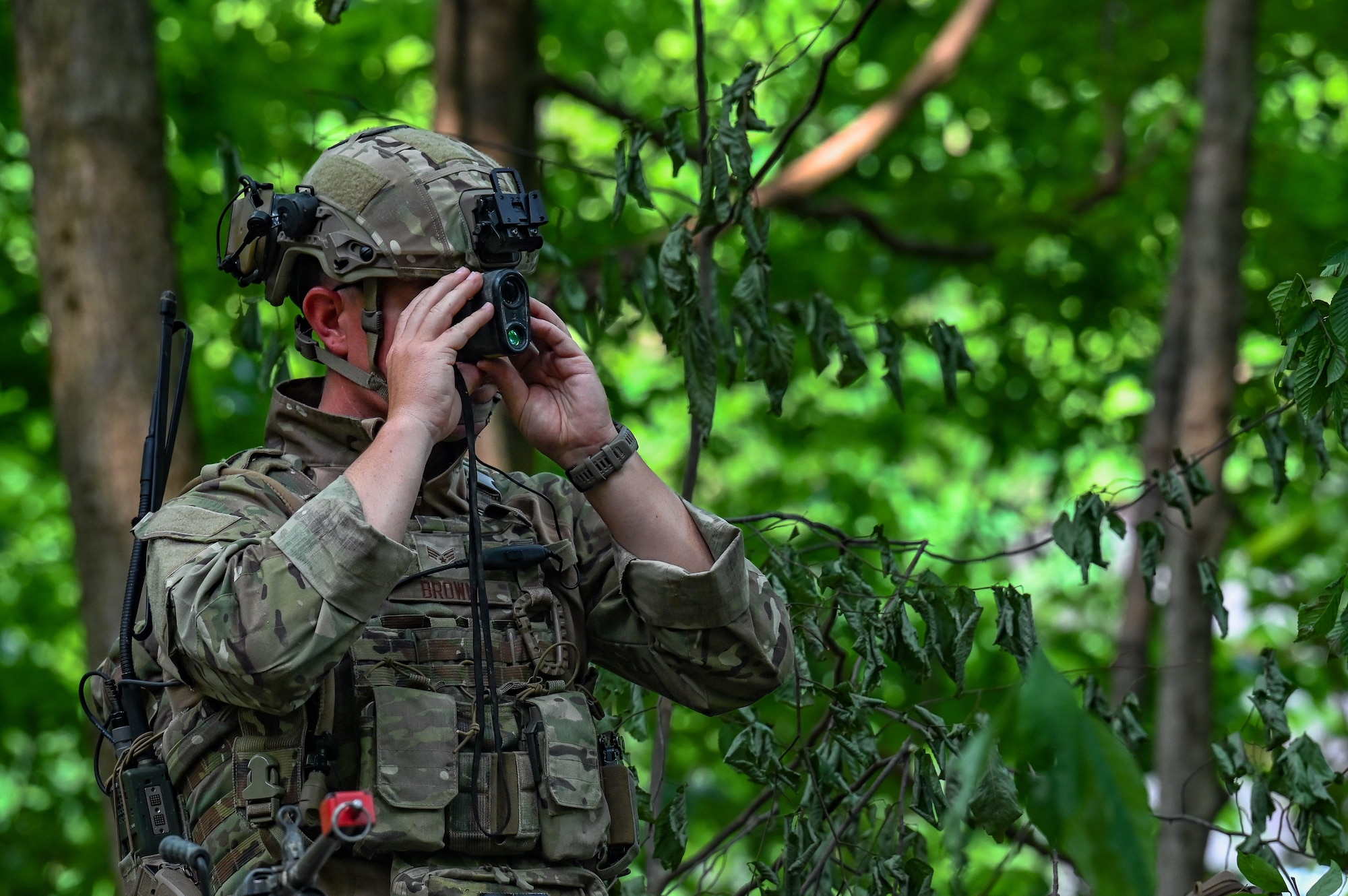 Senior Airman Kody Brown, a Defender assigned to the 301st Security Forces Squadron, Carswell Field, Naval Air Station Joint Reserve Base Fort Worth, Texas, uses a range estimator to gauge the distance to an objective on June 15, 2023, at Camp James A. Garfield Joint Military Training Center, Ohio.
