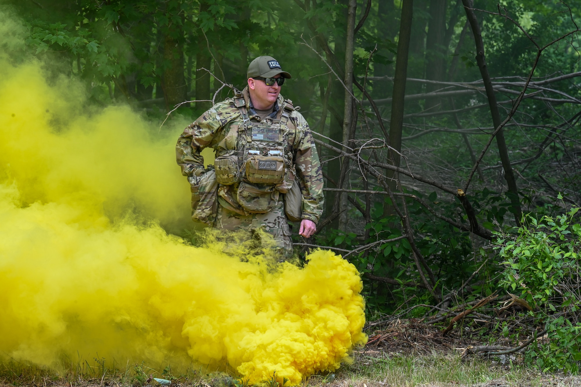 Senior Master Sgt. Daniel Chase, the Integrated Defense Leadership Course chief, assigned to the 310th Security Forces Squadron, Schriever Space Force Base, Colorado, activates a smoke canister for a training exercise on June 15, 2023, at Camp James A. Garfield Joint Military Training Center, Ohio.