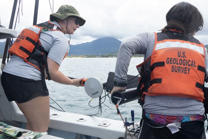 Researchers with the U.S. Geological Survey St. Petersburg Coastal and Marine Science Center, take down a pole camera during a geological survey, Marine Corps Base Hawaii, May 12, 2023. The survey mapped the nearshore coast offshore of Fort Hase beach to help predict coastal erosion. The USGS Center is working in conjunction with the University of Hawaii in a 5 year project to provide data of the sea floor to help UH place artificial and living coral reefs that will promote sea life growth in the area. (U.S. Marine Corps photo by Cpl. Chandler Stacy)