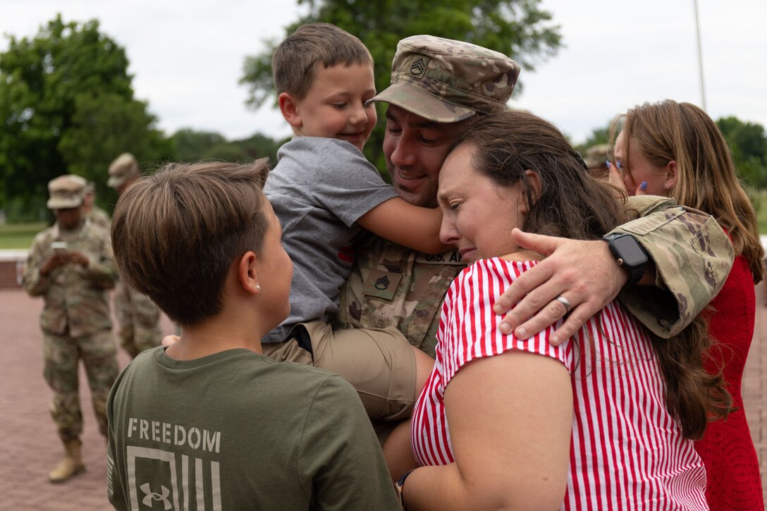 Staff. Sgt Michael Kadlec and his family reunite at the 18th Financial Support Center redeployment ceremony in front of Fowler Hall on Fort Knox, Kentucky, June 23, 2023.