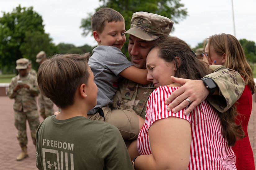 Staff. Sgt Michael Kadlec and his family reunite at the 18th Financial Support Center redeployment ceremony in front of Fowler Hall on Fort Knox, Kentucky, June 23, 2023.