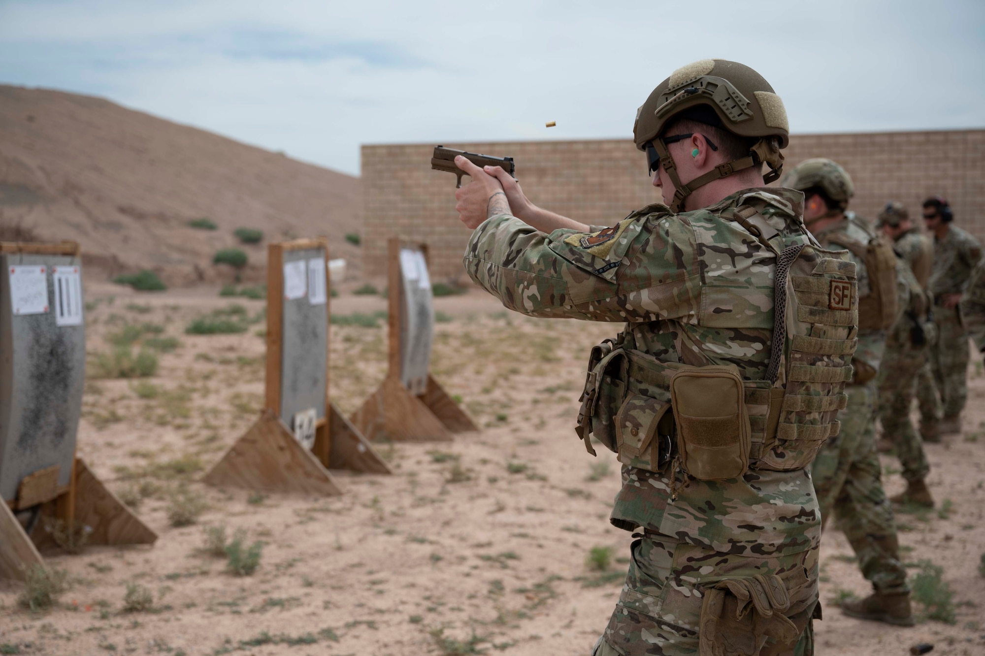 Airmen from the 49th Security Forces Squadron fire their weapons as part of the marksmanship portion of the Special Reaction Team tryouts at Holloman Air Force Base, New Mexico, June 9, 2023. The candidates were evaluated on their marksmanship skills to determine who would be selected for official SRT training at Fort Leonard Wood, Missouri. SRT tryouts determine the capability and accuracy of Airmen who are qualified to handle high-risk crisis situations. (U.S. Air Force photo by Airman 1st Class Michelle Ferrari)