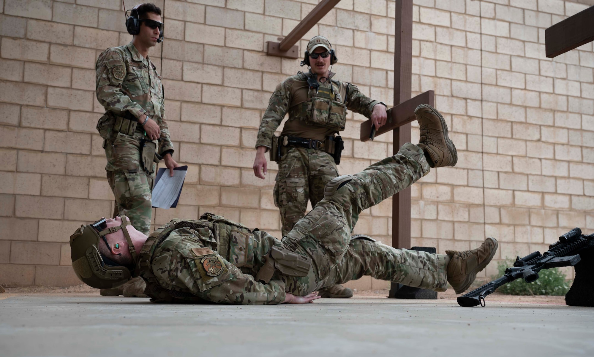 U.S. Air Force Staff Sgt. Chandler Docusen, left, 49th Security Forces Squadron unit trainer, and U.S. Air Force Capt. Jared Hafich, 49th SFS operations officer, right, evaluate U.S. Air Force Senior Airman Sean McClintock, 49th Security Forces Squadron Combat Arms instructor, as part of a Special Reactions Team assessment at Holloman Air Force Base, New Mexico, June 9, 2023. SRT tryouts determine the capability and accuracy of airmen who are qualified to handle high-risk crisis situations. (U.S. Air Force photo by Airman 1st Class Michelle Ferrari)