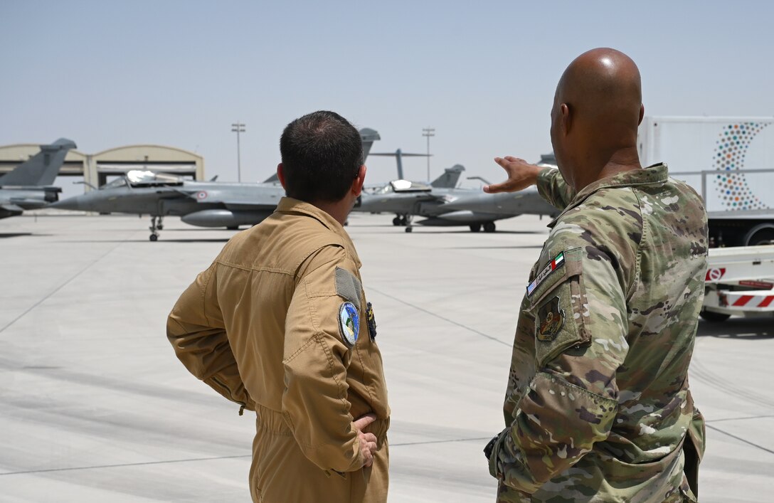 French Air and Space Force Lieutenant-colonel Bruno, left, and U.S. Air Force Col. Terence G. Taylor, 380th Air Expeditionary Wing commander, look at several French Rafale aircraft on the ramp after a mission brief for Pégase 2023 at Al Dhafra Air Base, United Arab Emirates, June 25, 2023. . During Pégase 2023, the French Air and Space Force are deploying 19 aircraft and 320 personnel to the Indo-Pacific region until Aug. 3, 2023. While there, French forces are scheduled to participate in multinational, large force exercises led by the U.S. Air Force and held with regional partners. (U.S. Air Force photo by Tech. Sgt. Alex Fox Echols III)