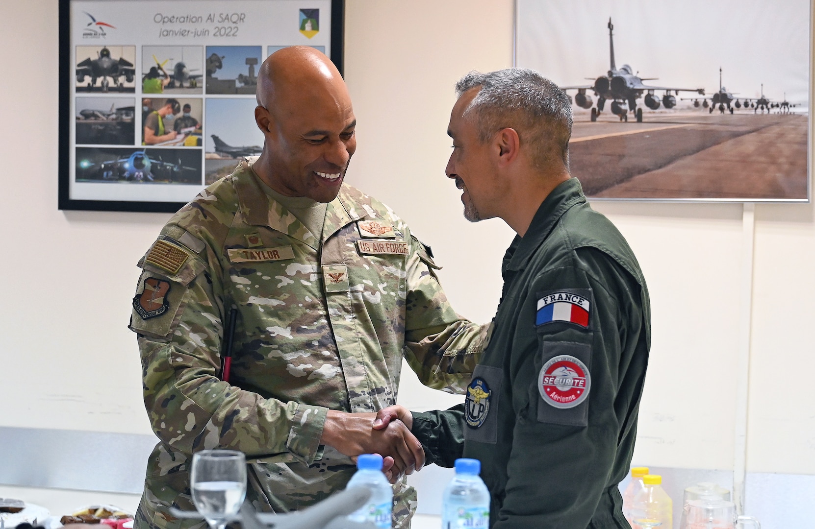 U.S. Air Force Col. Terence G. Taylor, left, 380th Air Expeditionary Wing commander, and Général de brigade aérienne Marc Le Bouil from the French Air and Space Force shake hands after a mission brief for Pégase 2023 at Al Dhafra Air Base, United Arab Emirates, June 25, 2023. During Pégase 2023, the French Air and Space Force are deploying 19 aircraft and 320 personnel to the Indo-Pacific region until Aug. 3, 2023. While there, French forces are scheduled to participate in multinational, large force exercises led by the U.S. Air Force and held with regional partners. (U.S. Air Force photo by Tech. Sgt. Alex Fox Echols III)