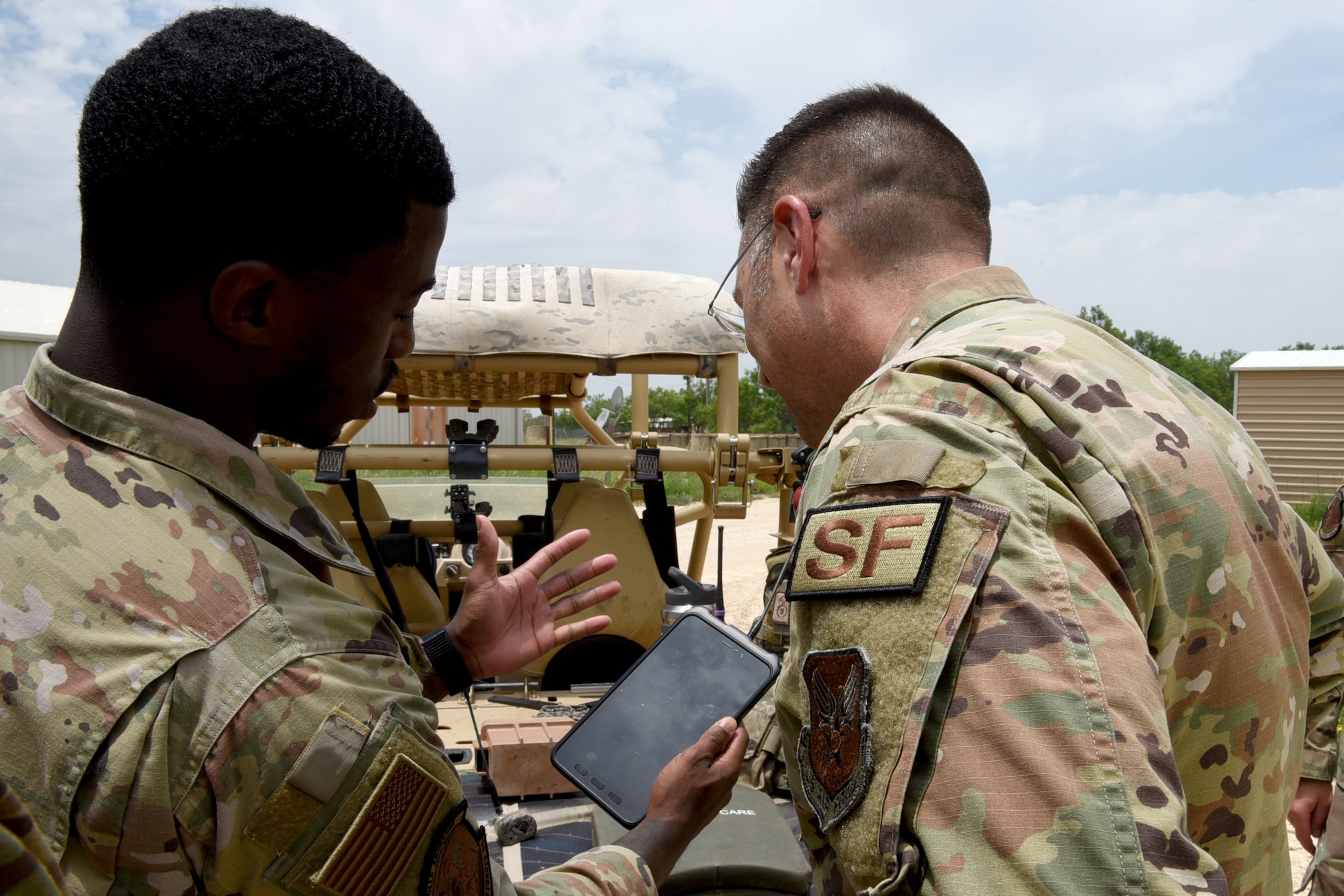 U.S. Air Force Senior Airman Frederick Lawrence, 7th Security Forces Squadron physical security section lead, showcases new technology to Brig. Gen. Thomas Sherman, Security Forces director, at Dyess Air Force Base, Texas, June 15, 2023. Sherman visited Dyess to present the 7th SFS with the Air Force Best Medium Sized Security Forces Squadron Award along with seeing new innovations including the robotic dog, a new GPS system, upgraded flack vests and more. (U.S. Air Force photo by Senior Airman Sophia Robello)