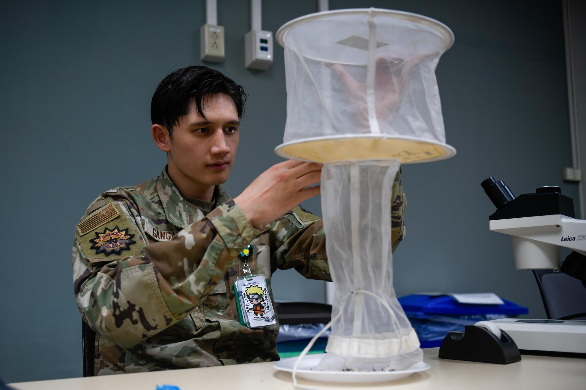 A service member empties a insect trap.