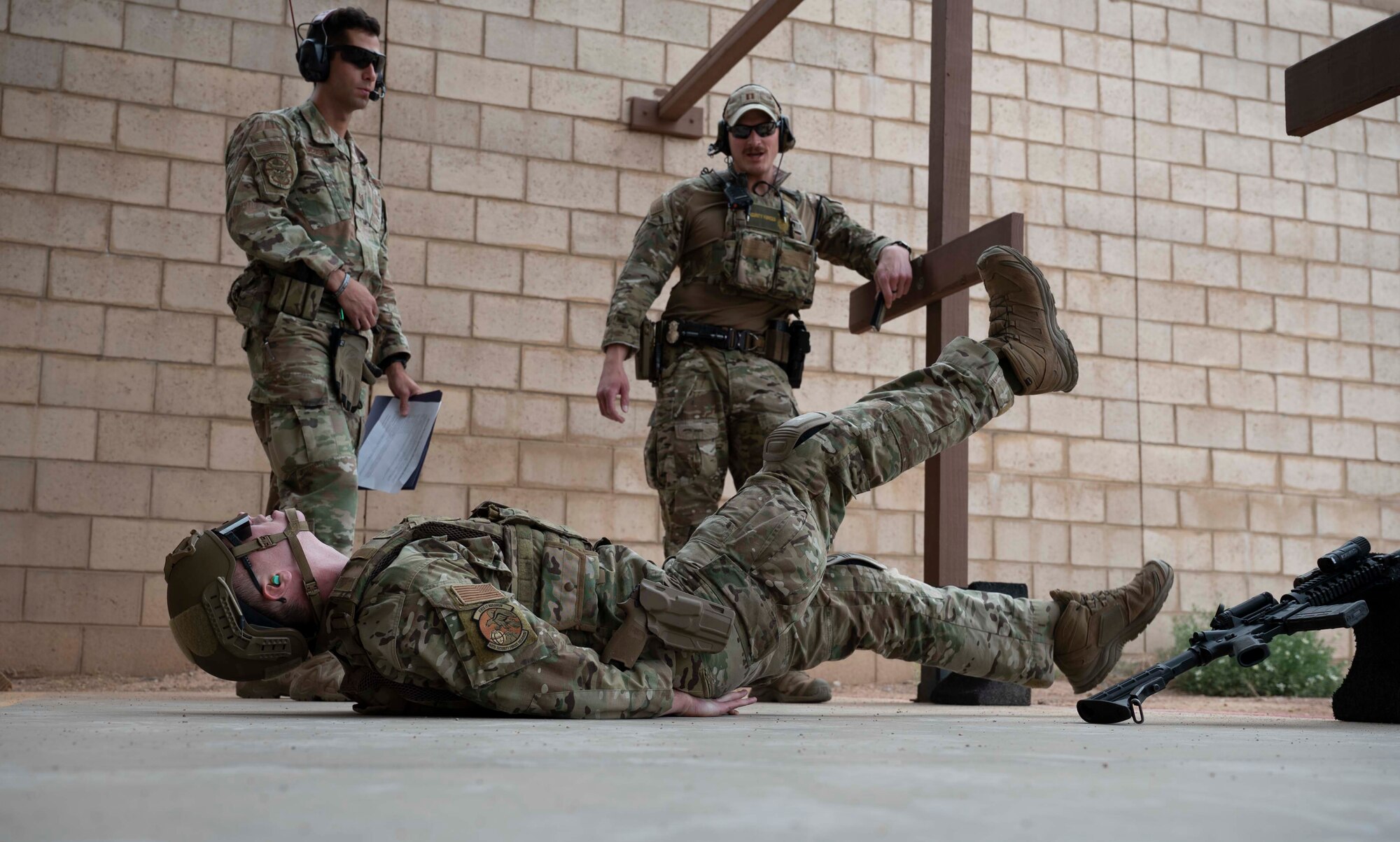 U.S. Air Force Staff Sgt. Chandler Docusen, left, 49th Security Forces Squadron unit trainer, and U.S. Air Force Capt. Jared Hafich, 49th SFS operations officer, right, evaluate U.S. Air Force Senior Airman Sean McClintock, 49th Security Forces Squadron Combat Arms instructor, as part of a Special Reactions Team assessment at Holloman Air Force Base, New Mexico, June 9, 2023. SRT tryouts determine the capability and accuracy of airmen who are qualified to handle high-risk crisis situations. (U.S. Air Force photo by Airman 1st Class Michelle Ferrari)