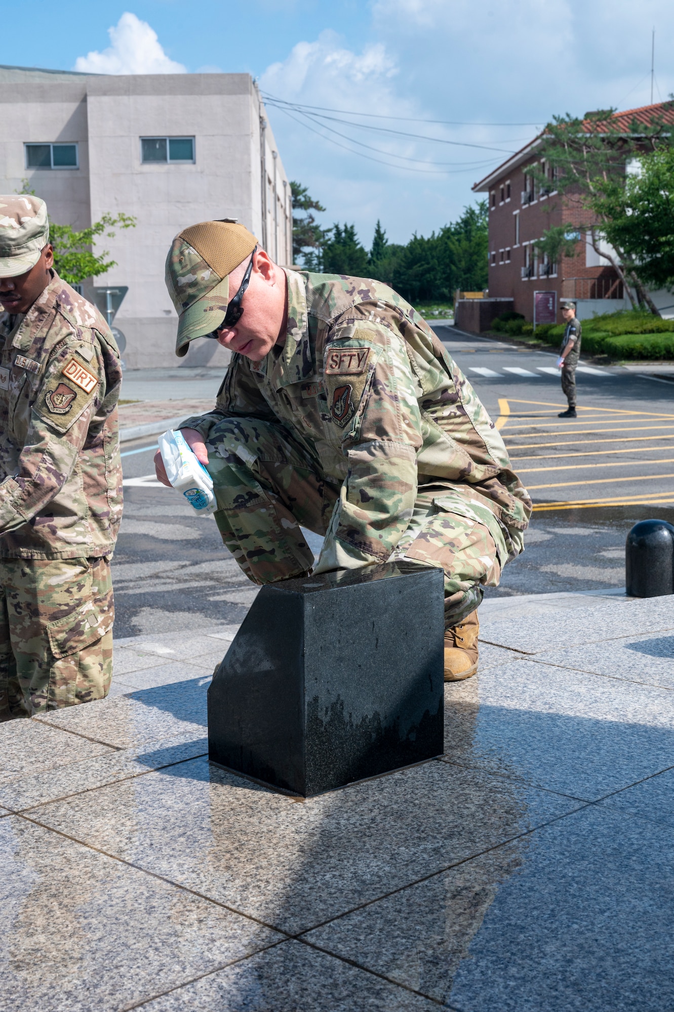 U.S. Air Force Master Sgt. Joel Schaarschmidt, 7th Air Force explosives safety manager, cleans a memorial’s plaque at Osan Air Base, Republic of Korea, June 22, 2023. The plaques displayed on the memorial were dedicated to each of the countries that came to the ROK’s aid during the Korean War. (U.S. Air Force photo by Senior Airman Aaron Edwards)