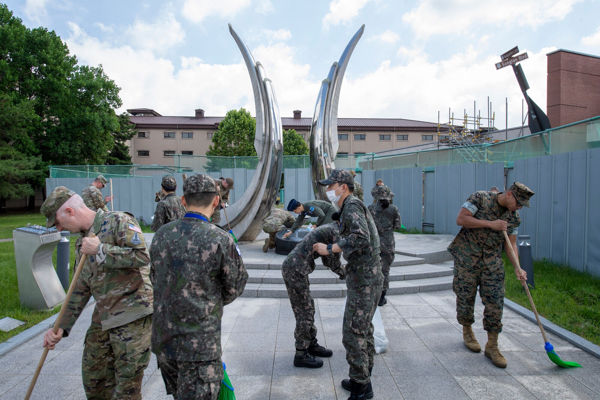 U.S. and Republic of Korea troops clean a memorial site at Osan Air Base, ROK, June 22, 2023. Troops cleaned the memorial to pay respects to those who made the ultimate sacrifice during the Korean War. (U.S. Air Force photo by Senior Airman Aaron Edwards)