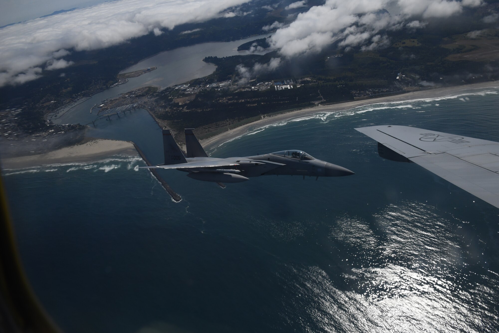 A U.S. Air Force F-15C Eagle from the 142nd Fighter Wing flies beside a KC-135 Stratotanker along the Oregon Coast after refueling during Operational Centennial Contact June 27, 2023. Operation Centennial Contact, a movement which included flights over Yellowstone National Park, Mount Rushmore and Glacier National Park, was part of Air Mobility Command’s celebration of 100 years air refueling operations and demonstrated the 92nd Air Refueling Wing’s global reach capabilities. This capability is essential for strategic and tactical operations, as well as humanitarian relief efforts in support of AMC, U.S. Transportation Command and Department of Defense priorities (U.S. Air Force Photo by 1st Lt. Ariana Wilkinson)