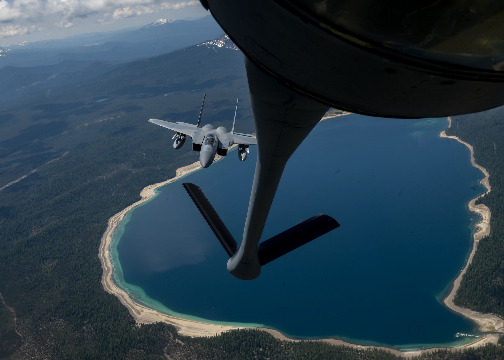 A KC-135 Stratotanker assigned to assigned to Fairchild Air Force Base, Washington, prepares to refuel an F-15C Eagle over Oregon as part of Operation Centennial Contact June 27, 2023. The movement, which also included flights over Yellowstone National Park, Mount Rushmore and Glacier National Park, was part of Air Mobility Command’s celebration of 100 years air refueling operations and demonstrated the 92nd Air Refueling Wing’s global reach capabilities. Since its inception in 1923, air refueling has become a crucial component of military and civilian aviation operations around the world by extending the range and endurance of aircraft and enabling them to complete missions that would otherwise be impossible or require multiple stops. As a result, this capability is essential for strategic and tactical operations, as well as humanitarian relief efforts in support of AMC, U.S. Transportation Command and Department of Defense priorities. (U.S. Air Force photo by Staff Sgt. Lawrence Sena)