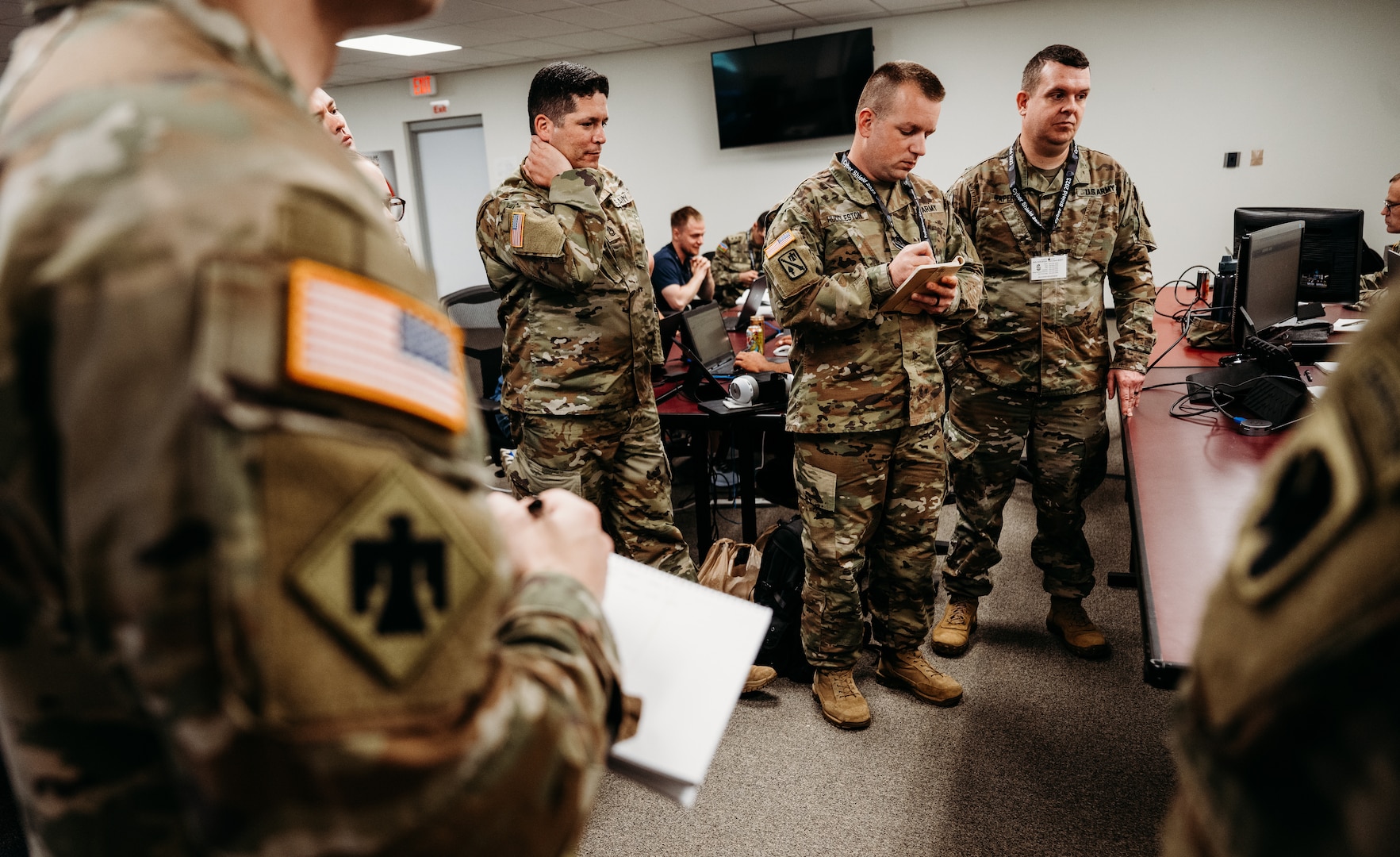 Members of the Oklahoma National Guard cyber defense team receives a mission update during Cyber Shield 2023, held at the Professional Education Center in Little Rock, Arkansas, June 10, 2023. With technology continuing to advance at an unprecedented pace along with its associated threats, members of the Oklahoma National Guard joined approximately 800 military and civilian cyber professionals from 35 states, including international partners, for this year’s Cyber Shield, June 2-16, 2023. This year's exercise, won by the Oklahoma team for the second year in a row, was centered on critical infrastructure protection, incident response, network defense with a specific tie to U.S. Transportation Systems Sector and other crucial aspects of cybersecurity. (Oklahoma National Guard photo by Master Sgt. Mireille Merilice-Roberts)