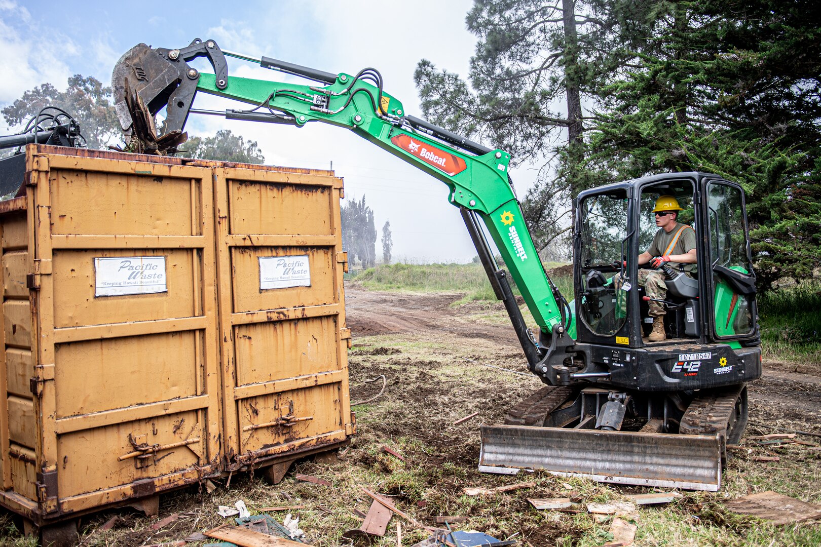 Spc. Austin Mears, a Stillwater, Oklahoma resident serving as a horizontal construction engineer with the 3120th Engineer Support Company, 120th Engineer Battalion, 90th Troop Command, Oklahoma Army National Guard, loads debris into a dumpster during renovations at the Girl Scouts of Hawaii's Camp Kilohana near Pahokuloa Training Area, Hawaii, June 14, 2023.

The Soldiers of the 3120th ESC are taking part in an Innovative Readiness Training program to improve their skills as Army engineers while providing the Girl Scout camp with improvements. (Oklahoma National Guard photo by Sgt. Anthony Jones)