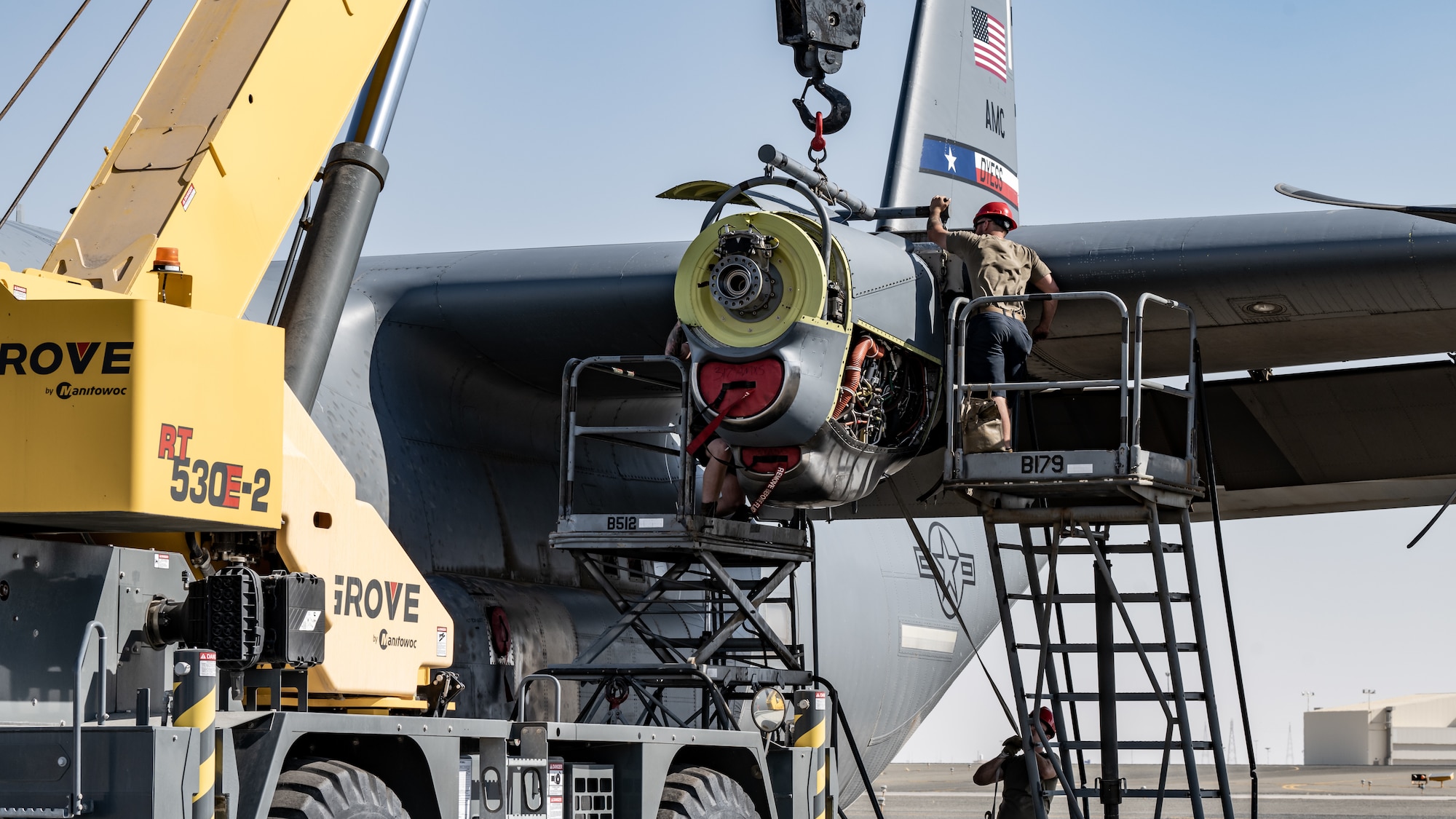 386th Expeditionary Aircraft Maintenance Squadron aerospace propulsion technicians work together to install an engine onto a C-130J Super Hercules at Ali Al Salem Air Base, Kuwait, June 27, 2023. The 386th Air Expeditionary Wing is the primary airlift hub and gateway for delivering combat power to joint and coalition forces in the U.S. Central Command area of responsibility. (U.S. Air Force photo by Staff Sgt. Kevin Long)
