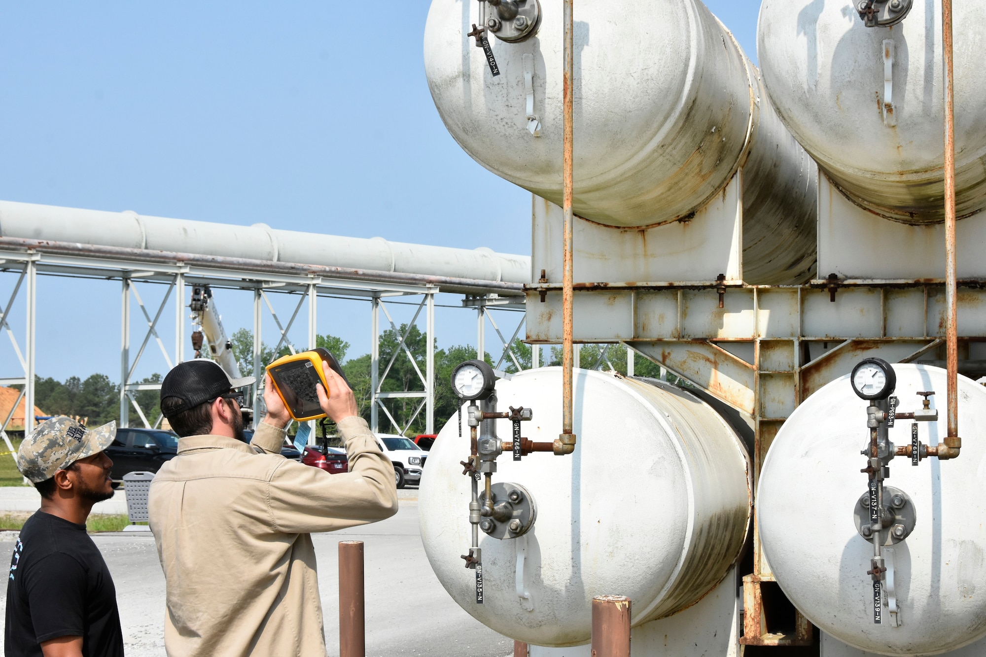 Wayne Horton, ultrasound lead at Arnold Air Force Base, Tenn., left, looks on as Robert Hastings, an electrician at Arnold AFB, uses a recently-acquired acoustic imager to check several tanks for leaks May 26, 2023. The imager can identify leaks in compressed air, gas and vacuum systems, and allows users to see the exact location of a leak on a digital image displayed on the device. It can also determine the distance, size and decibel level of a leak. The imager was one of seven projects that received funding through the 2023 AEDC Spark Tank program, which allows members of the AEDC workforce to propose suggestions for improving AEDC processes, products and test capabilities. (U.S. Air Force photo by Bradley Hicks)