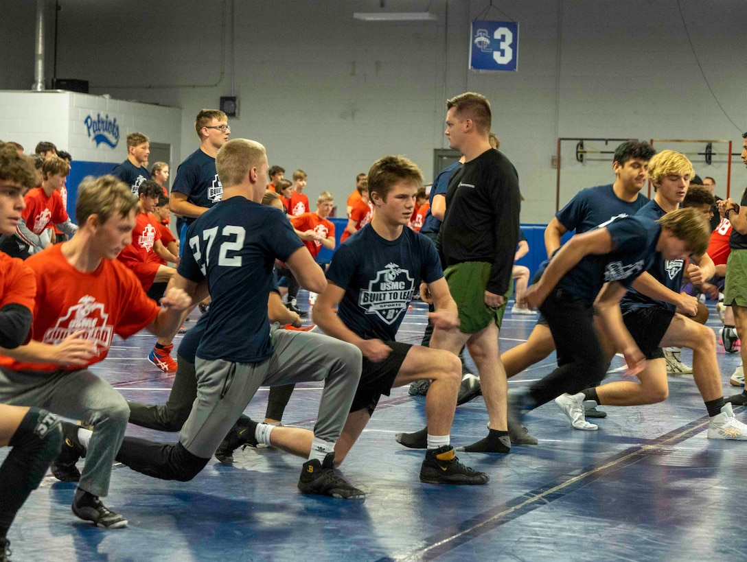 U.S. Marine Corps Sgt. William Larkin, a recruiter with Marine Corps Recruiting Station Columbus, leads warm up exercises with high school wrestlers at the United States Marine Corps Sports Leadership Academy October 15, 2022, at Olentangy Liberty High School in Columbus, Ohio. The United States Marine Corps Sports Leadership Academy is a free event that helps high school wrestlers strengthen their wrestling skills and learn leadership principles from Marines. (U.S. Marine Corps Photo by LCpl Zane Ortega/Released)