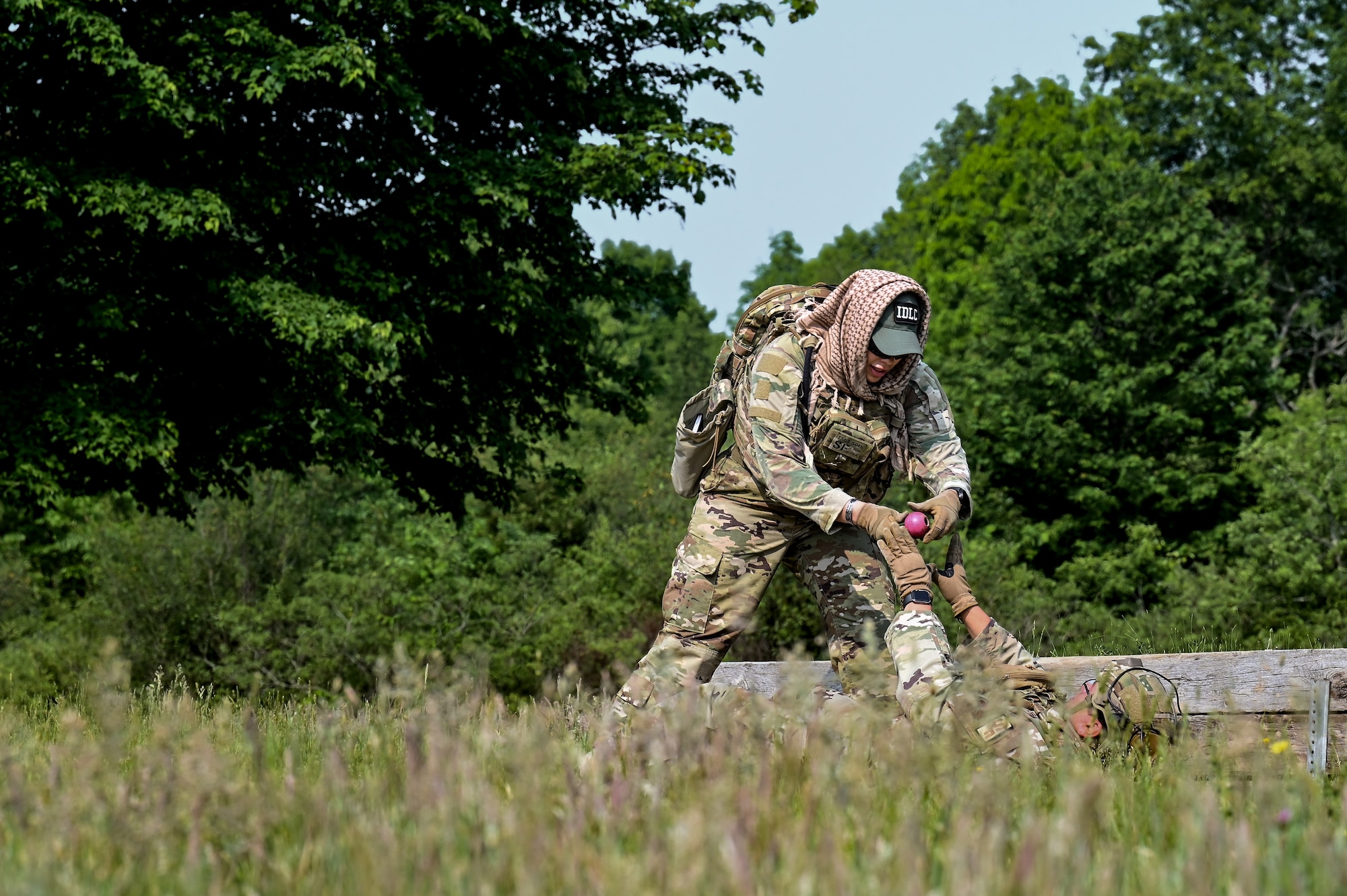 Tech. Sgt. Arica Sims, an Integrated Defense Leadership Course cadre member assigned to the 910th Security Forces Squadron, Youngstown Air Reserve Station, Ohio, hands a practice grenade to an IDLC student on June 7, 2023, at Camp James A. Garfield Joint Military Training Center, Ohio.