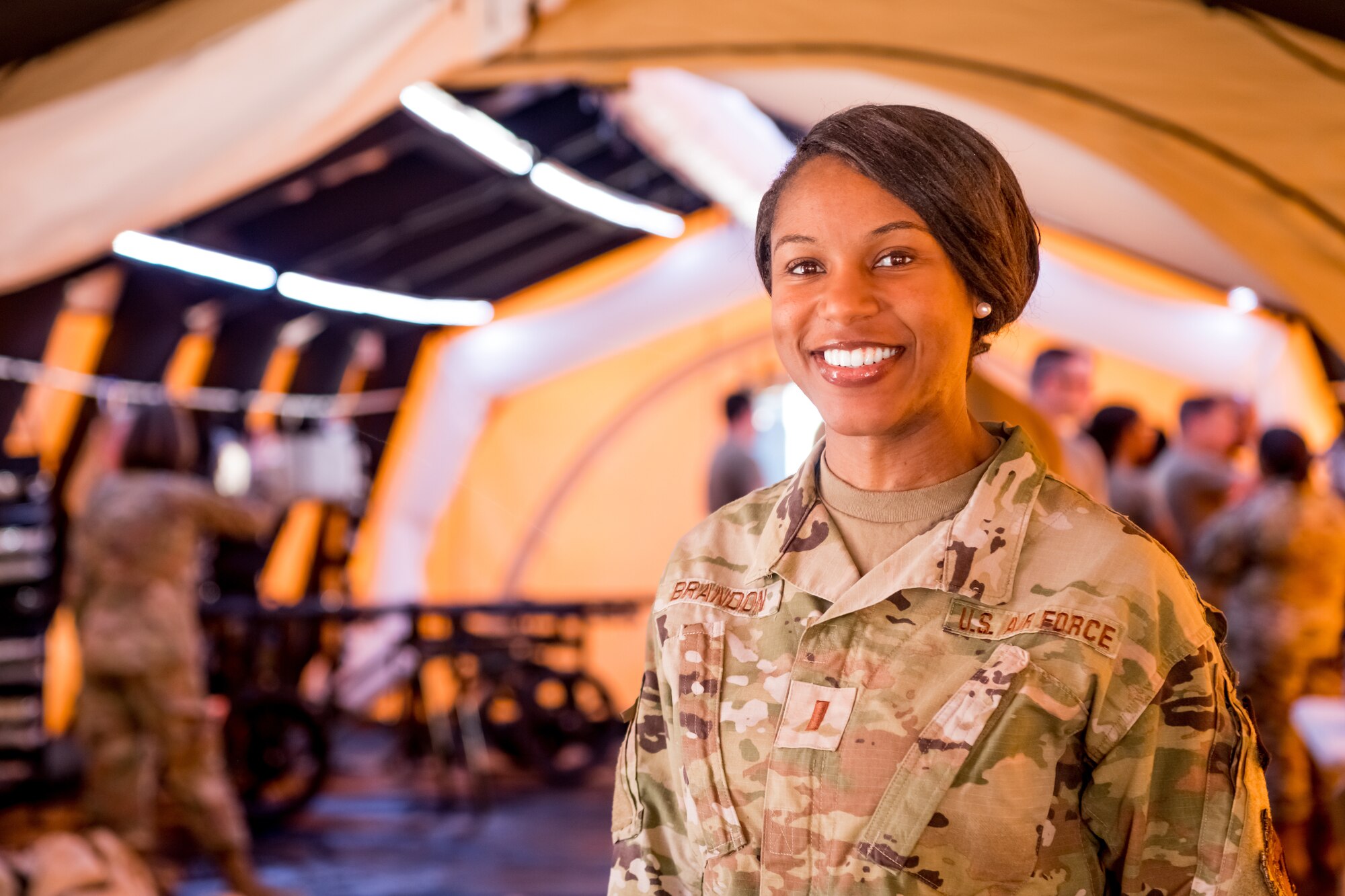 photo of Airman inside medical tent with others in the background