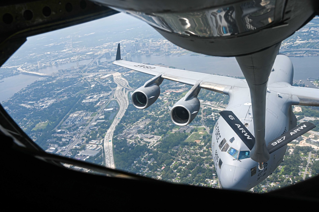 A large plane is refueled in mid air.