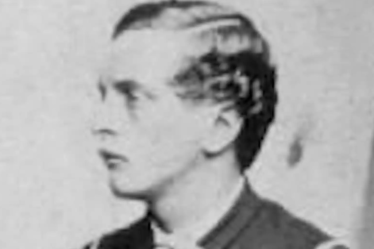 A man looks toward the right while posing for a photo.