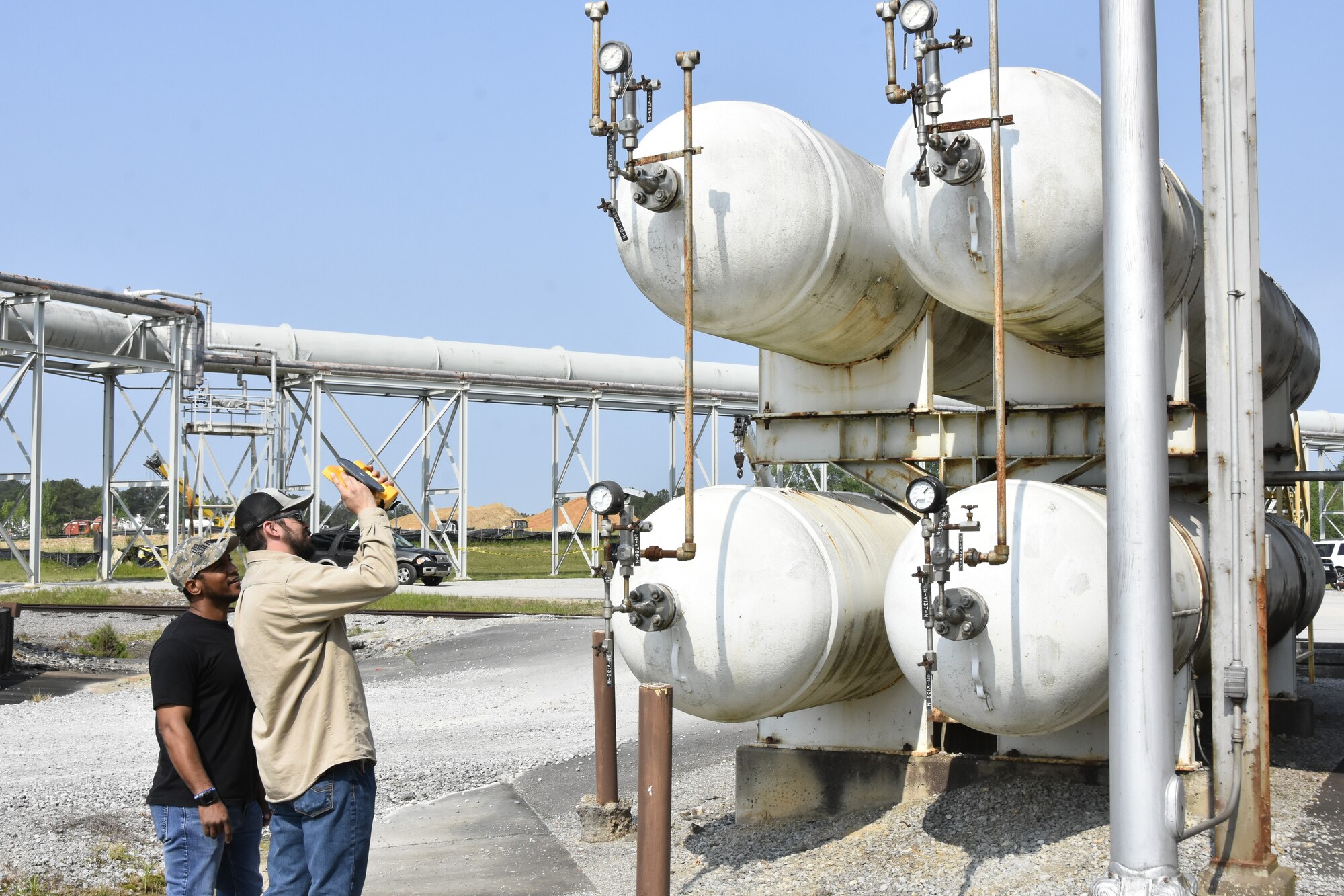 Wayne Horton, ultrasound lead at Arnold Air Force Base, Tenn., left, looks on as Robert Hastings, an electrician at Arnold AFB, uses a recently-acquired acoustic imager to check several tanks for leaks May 26, 2023. The imager can identify leaks in compressed air, gas and vacuum systems, and allows users to see the exact location of a leak on a digital image displayed on the device. It can also determine the distance, size and decibel level of a leak. The imager was one of seven projects that received funding through the 2023 AEDC Spark Tank program, which allows members of the AEDC workforce to propose suggestions for improving AEDC processes, products and test capabilities. (U.S. Air Force photo by Bradley Hicks)
