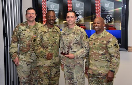 Shortly before his active-duty retirement, Master Sgt. Wesley Ladlee, center right, receives the prestigious Dean R. Ohlsen Award of Excellence during a ceremony June 1, 2023, at Fort Detrick, Maryland. Also pictured are U.S. Army Medical Logistics Command leaders, from left, Command Chief Warrant Officer 5 Lee Nelson, Commander Col. Gary Cooper and Sgt. Maj. Akram Shaheed.
