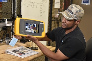 Wayne Horton, ultrasound lead at Arnold Air Force Base, Tenn., uses the leak simulator in the Innovation Center May 26, 2023, to demonstrate the recently-acquired acoustic imager that can identify leaks in compressed air, gas and vacuum systems. The imager allows users to see the exact location of a leak on a digital image displayed on the device. It can also determine the distance, size and decibel level of a leak. The imager was one of seven projects that received funding through the 2023 AEDC Spark Tank program, which allows members of the AEDC workforce to propose suggestions for improving AEDC processes, products and test capabilities. (U.S. Air Force photo by Bradley Hicks)