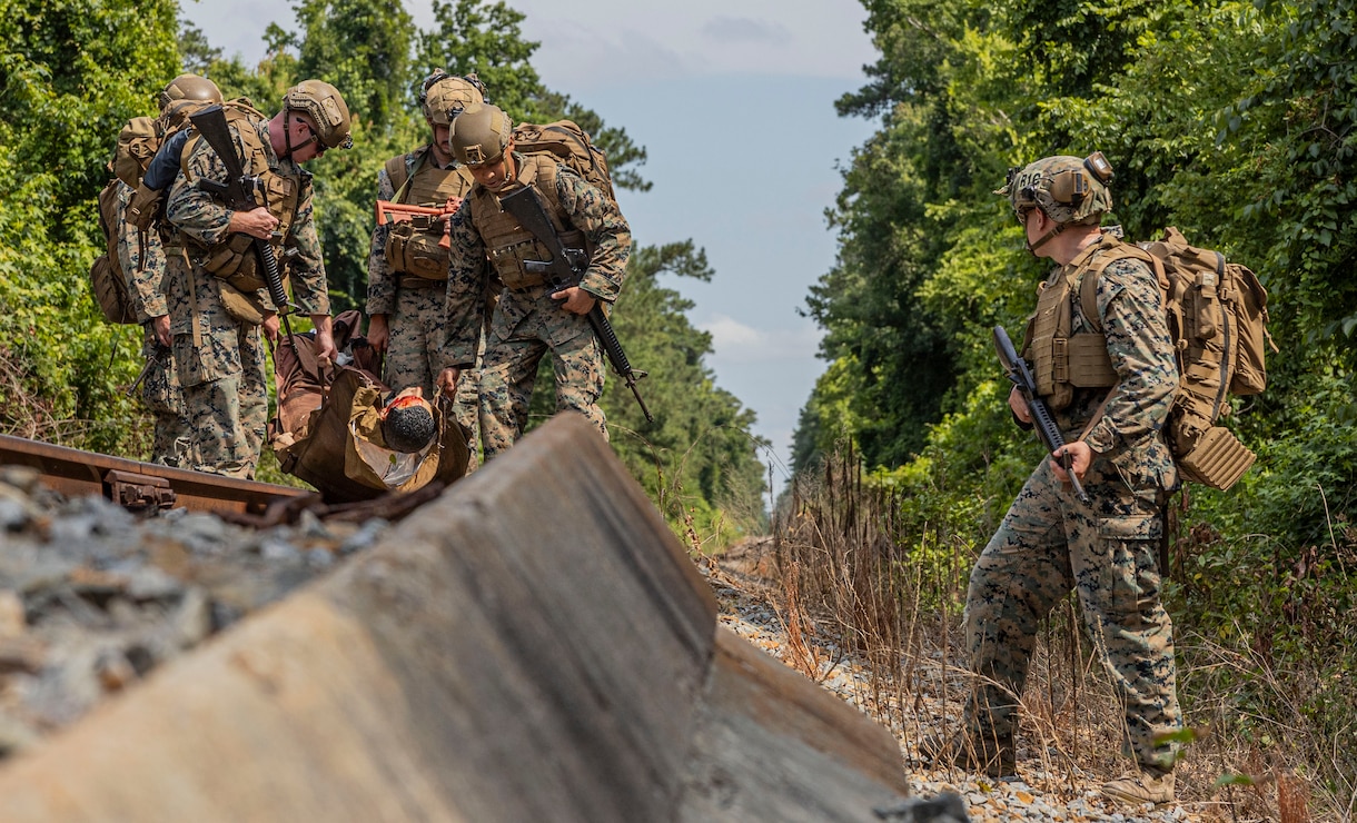 U.S. Navy Corpsman and Marines with 2d Marine Division, transport a patient during a Doc Kent competition on Camp Lejeune, North Carolina, June 15, 2023. The competition showcases the capabilities of executing tactical combat casualty care in austere environments by utilizing various evacuation platforms to move from point of injury to higher echelons of care. (U.S. Marine Corps photo by Cpl. Megan Ozaki)