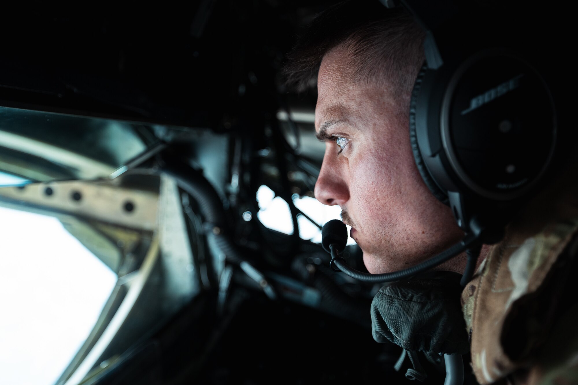 Airman concentrates on refueling aircraft in flight.