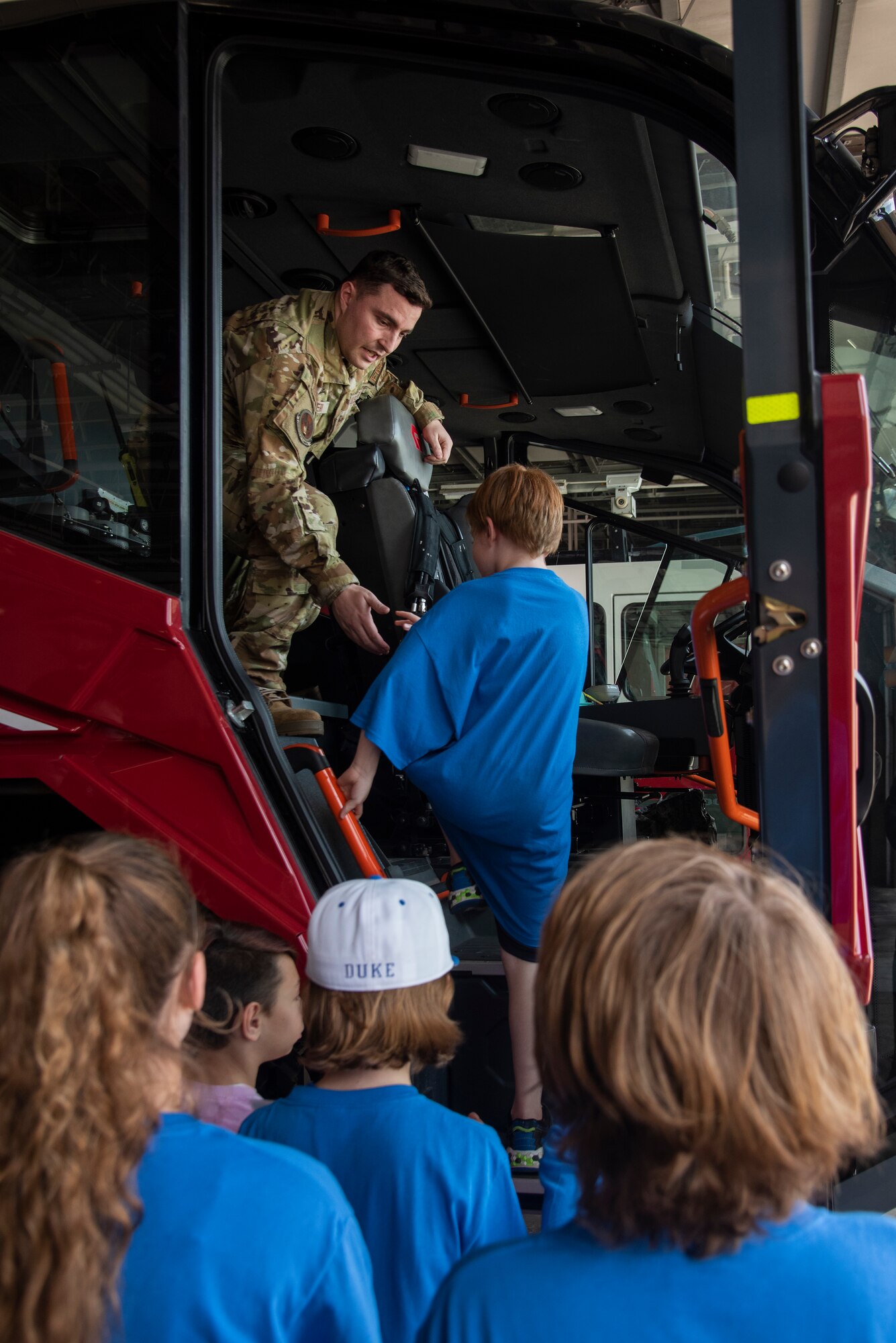 Airman 1st Class Kristopher Imeri, 4th Civil Engineer Squadron firefighter, helps a Wayne County student climb into a fire fighting vehicle during an Aerospace Camp community event at Seymour Johnson Air Force Base, North Carolina, June 20, 2023. The Aerospace Camp gave students an opportunity to meet Airmen who use science, technology, engineering and math (STEM) when performing their mission, and tour locations on base to learn how Team Seymour contributes to the Air Combat Command and U.S. Air Force mission. Community events like this help strengthen the partnership shared between the base and local community, and develop our youth to progress as future leaders. (U.S. Air Force photo by Tech. Sgt. Christopher Hubenthal)