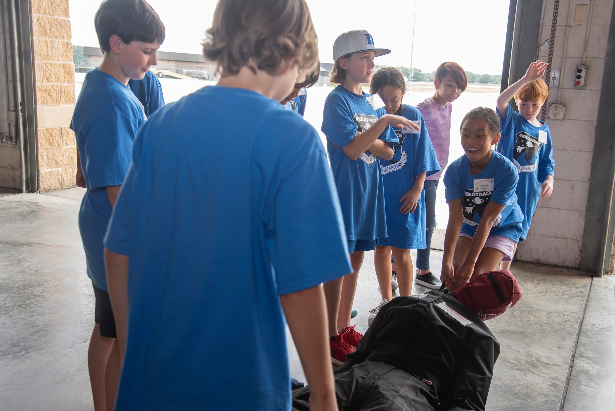 Wayne County students attempt to drag a 4th Civil Engineer Squadron fire department training dummy during an Aerospace Camp community event at Seymour Johnson Air Force Base, North Carolina, June 20, 2023. During the event, 36 students were able to visit various locations on base including the 4th CES fire department, 4th Fighter Wing Aircrew Flight Equipment section, 4th Operations Squadron base operations and weather flight, and the installation’s flightline. Community events like this help strengthen the partnership shared between the base and local community, and develop our youth to progress as future leaders. (U.S. Air Force photo by Tech. Sgt. Christopher Hubenthal)