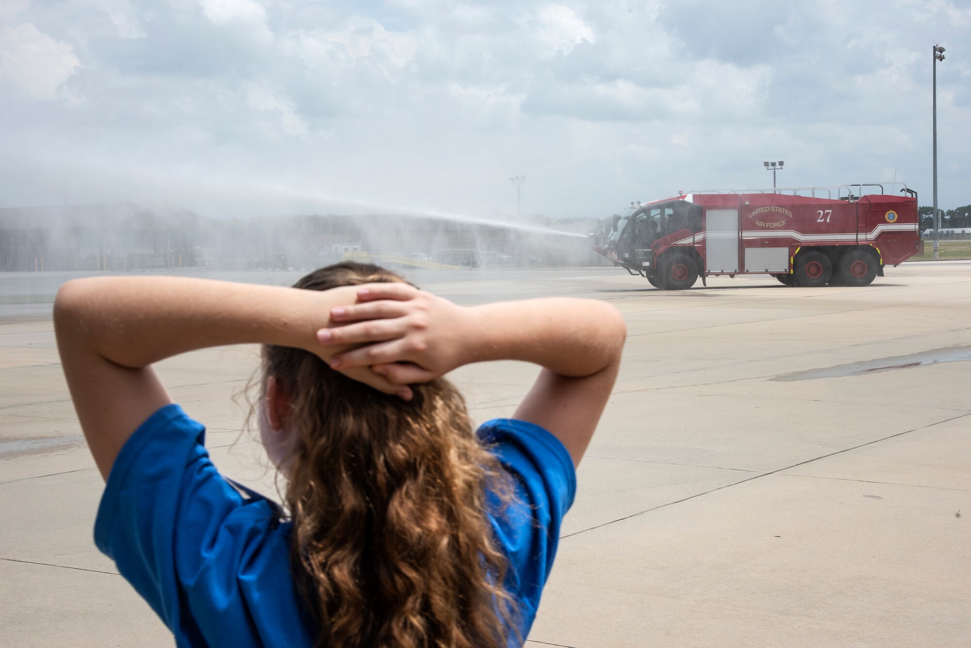 A Wayne County student watches Airmen of the 4th Civil Engineer Squadron operate a fire truck during an Aerospace Camp community event at Seymour Johnson Air Force Base, North Carolina, June 20, 2023. During the event, 36 students were able to visit various locations on base including the 4th CES fire department, 4th Fighter Wing Aircrew Flight Equipment section, 4th Operations Squadron base operations and weather flight, and the installation’s flightline. Community events like this help strengthen the partnership shared between the base and local community, and develop our youth to progress as future leaders. (U.S. Air Force photo by Tech. Sgt. Christopher Hubenthal)