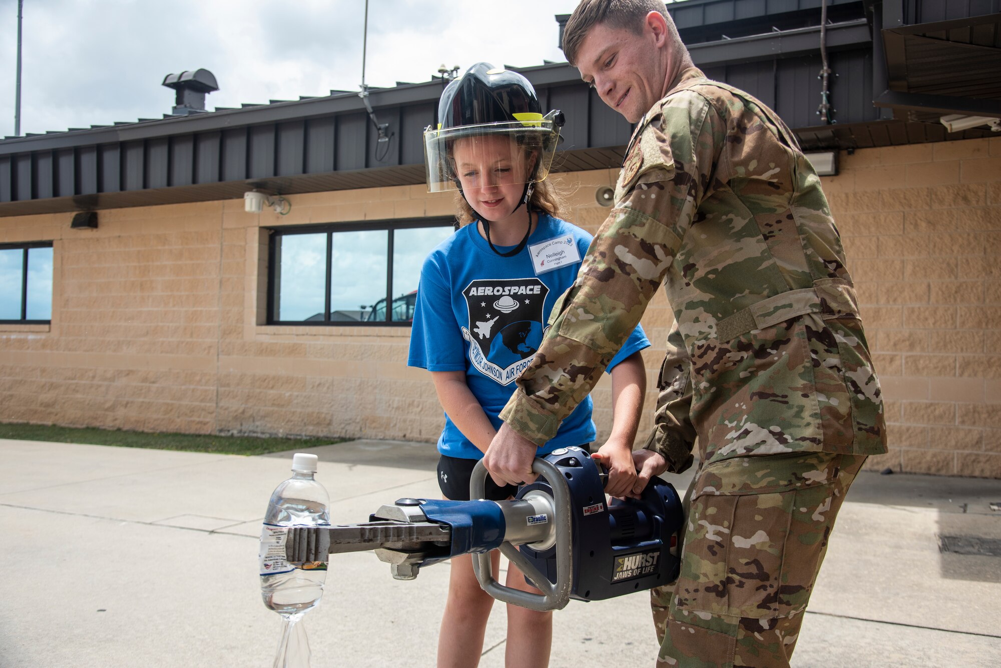 Airman 1st Class Tyler Johnson, 4th Civil Engineer Squadron firefighter, shows a Wayne County student how to use a fire fighting tool, the “Jaws of Life,” during an Aerospace Camp community event at Seymour Johnson Air Force Base, North Carolina, June 20, 2023. The Aerospace Camp gave students an opportunity to meet Airmen who use science, technology, engineering and math (STEM) when performing their mission, and tour locations on base to learn how Team Seymour contributes to the Air Combat Command and U.S. Air Force mission. Community events like this help strengthen the partnership shared between the base and local community, and develop our youth to progress as future leaders. (U.S. Air Force photo by Tech. Sgt. Christopher Hubenthal)