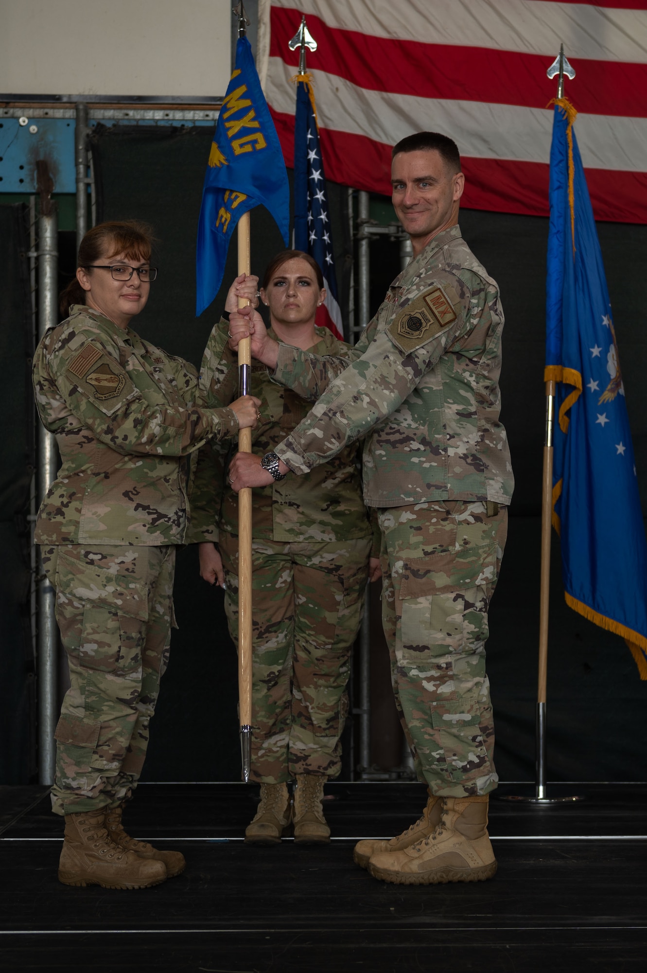 U.S. Air Force Maj. Michael Makaryk, right, 335th Fighter Generation Squadron commander, passes the guidon to U.S. Air Force Col. Kathryn Roman, left, 4th Maintenance Group commander, during a change of command ceremony at Seymour Johnson Air Force Base, North Carolina, June 23, 2023. Base and community leadership, along with friends and family of the squadron’s incoming and outgoing commanders, gathered to witness the traditional passing of the guidon. (U.S. Air Force photo by Airman 1st Class Rebecca Sirimarco-Lang)