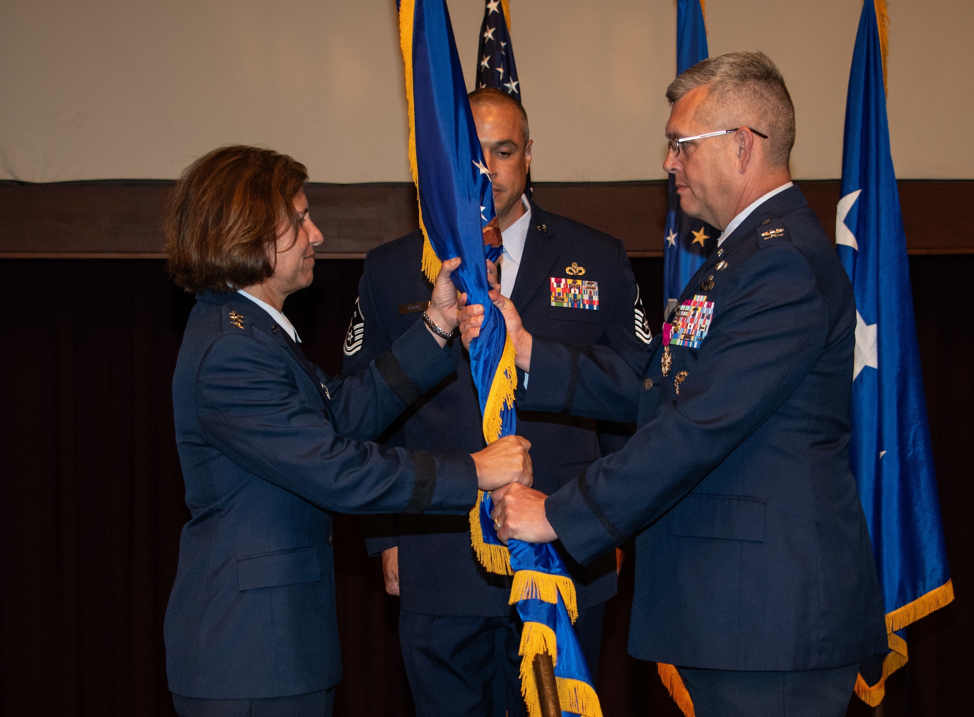 Col. Anthony D. Babcock relinquishes command by passing the Thomas N. Barnes Center for Enlisted Education organizational flag to Lt. Gen. Andrea D. Tullos, Air University commander and president, during a change of command ceremony at the Senior Noncommissioned Officer Academy on Maxwell Air Force Base - Gunter Annex, June 28, 2023. (U.S. Air Force photo/Brian Ferguson)